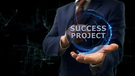 Businessman shows concept hologram Success project on his hand. Man in business suit with future technology screen and modern cosmic backgroundの写真素材