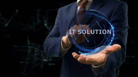 Businessman shows concept hologram IT solution on his hand. Man in business suit with future technology screen and modern cosmic backgroundの写真素材