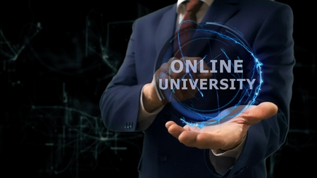 Businessman shows concept hologram Online university on his hand. Man in business suit with future technology screen and modern cosmic backgroundの写真素材