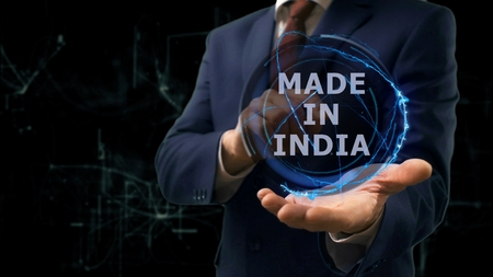 Businessman shows concept hologram Made in India on his hand. Man in business suit with future technology screen and modern cosmic backgroundの写真素材