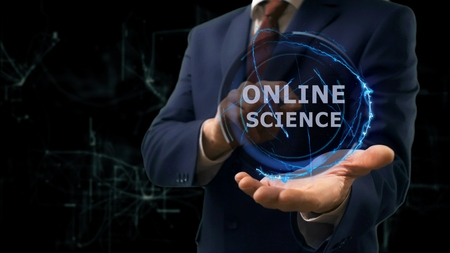 Businessman shows concept hologram Online science on his hand. Man in business suit with future technology screen and modern cosmic backgroundの写真素材