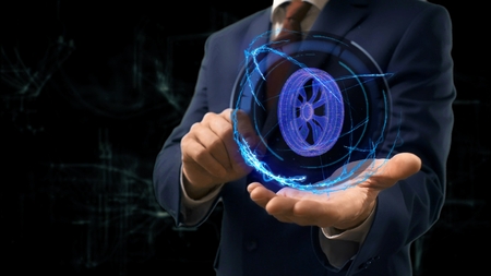 Businessman shows concept hologram Wheel on his hand. Man in business suit with future technology screen and modern cosmic backgroundの写真素材
