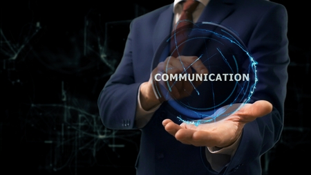 Businessman shows concept hologram Communication on his hand. Man in business suit with future technology screen and modern cosmic backgroundの写真素材