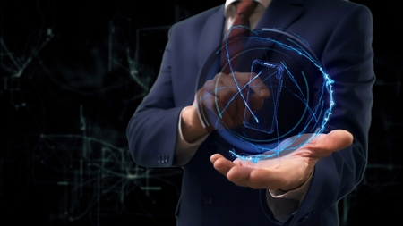 Businessman shows concept hologram 3d smartphone on his hand. Man in business suit with future technology screen and modern cosmic backgroundの写真素材