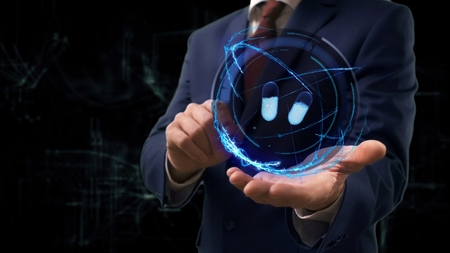 Businessman shows concept hologram 3d pills on his hand. Man in business suit with future technology screen and modern cosmic backgroundの写真素材