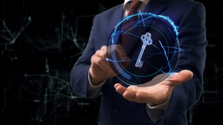 Businessman shows concept hologram 3d key on his hand. Man in business suit with future technology screen and modern cosmic backgroundの写真素材