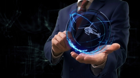 Businessman shows concept hologram 3d helicopter on his hand. Man in business suit with future technology screen and modern cosmic backgroundの写真素材