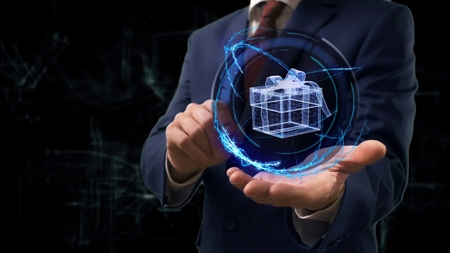 Businessman shows concept hologram 3d gift on his hand. Man in business suit with future technology screen and modern cosmic backgroundの写真素材
