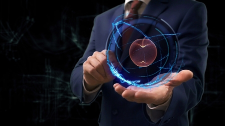 Businessman shows concept hologram 3d apple on his hand. Man in business suit with future technology screen and modern cosmic background