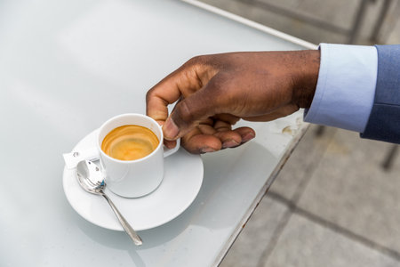 Close up of a man's hand holding a cup of espresso coffeeの写真素材