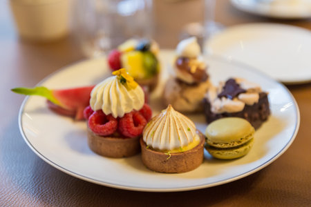 Close up of assorted cakes on a white plate in a cafe.の写真素材