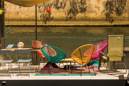 Colorful chairs on the terrace of a restaurant on the riverの写真素材