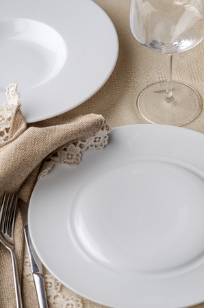 Two white restaurant plate and wine glass on light background.の写真素材