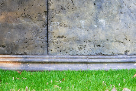 Interior of an old castle with a concrete wall and a green lawn.の写真素材