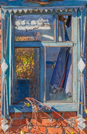 An old abandoned brick house with a broken window, closeup. As background for design of crisis.の写真素材