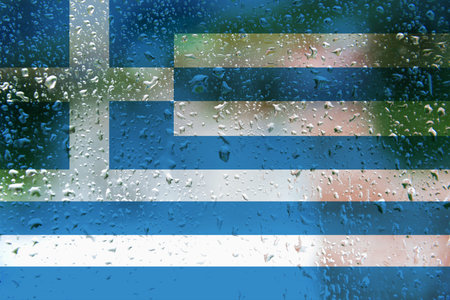 Greek flag with the texture of the rain drops on a window glassの写真素材