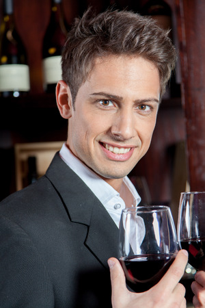 Pretty man with a glass of wineの写真素材