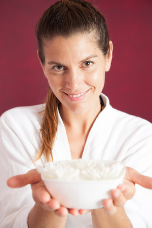Woman holding  flower petals in a bowlの写真素材