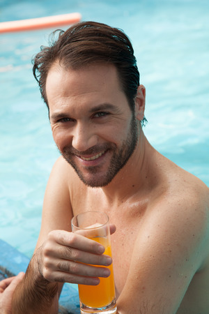Happy man drinking a glass of juiceの写真素材