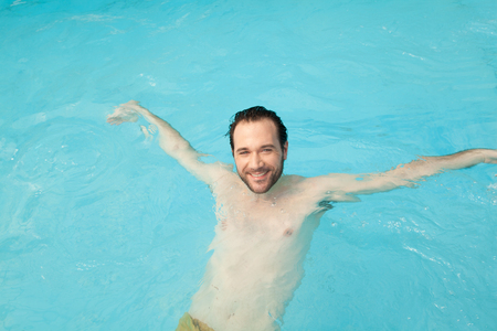 Happy man relaxing in the poolの写真素材