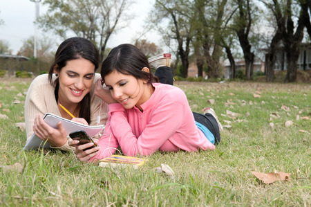 Women chatting by phone outsideの写真素材