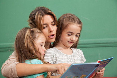 Teacher reading a book with her studentsの写真素材