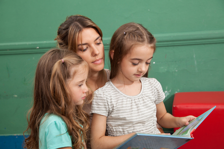 Teacher reading a book with her studentsの写真素材