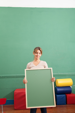Young woman holding a blackboardの写真素材
