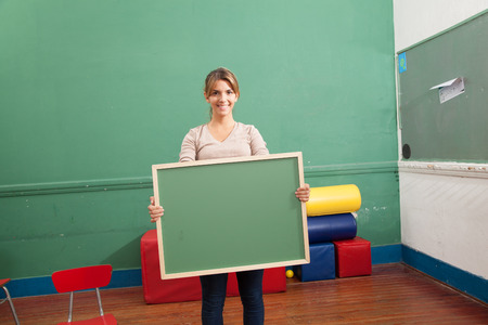 Young woman holding a blackboardの写真素材