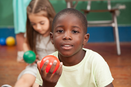 African boy holding a red ballの写真素材