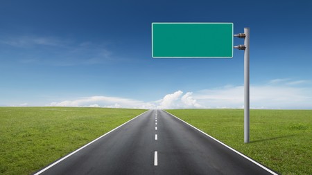 empty road through fields with blank road-signの写真素材