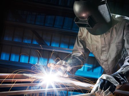 man welding in workshop with safety precautionの写真素材