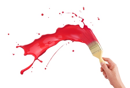 hand holding paintbrush creating red paint splashの写真素材