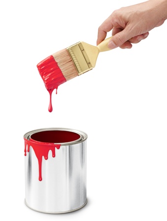 hand holding paintbrush after dipping into its bucketの写真素材