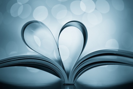 pages of book folded into heart shape against bokeh lights backgroundの写真素材