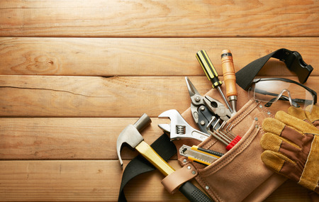 tools in tool belt on wood planks with copy spaceの写真素材