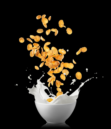 corn flakes dropping into bowl causing milk splashの写真素材