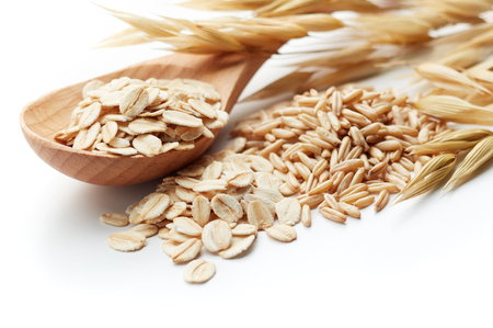 scoop and pile of oatmeal with its unprocessed grains and plantの写真素材