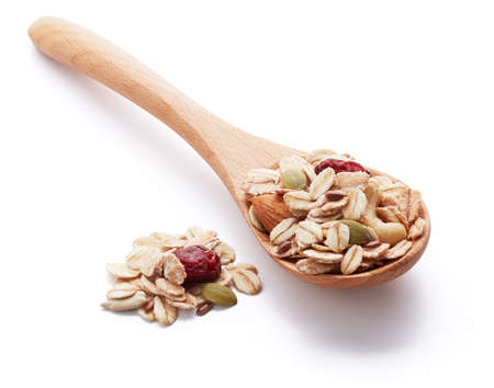 heap of muesli with wooden spoonの写真素材