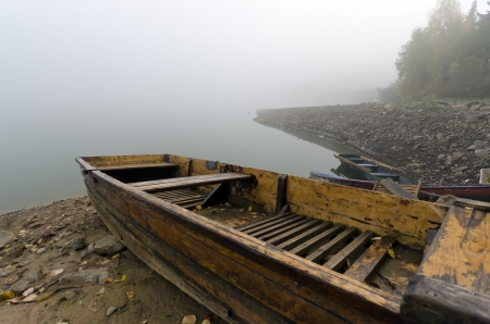 Small boat on the lake shore in the mistの写真素材
