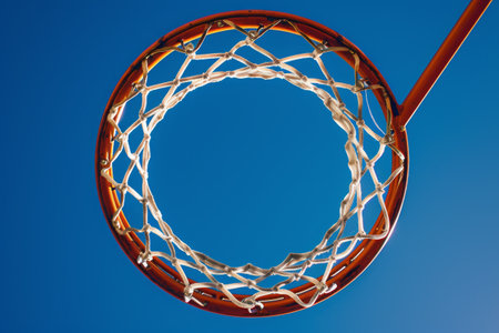Basketball Hoop With Blue Sky Background, Detail of a basketball hoop with net, creating a pattern of lines and curves against a bright, clear sky, AI Generatedの素材