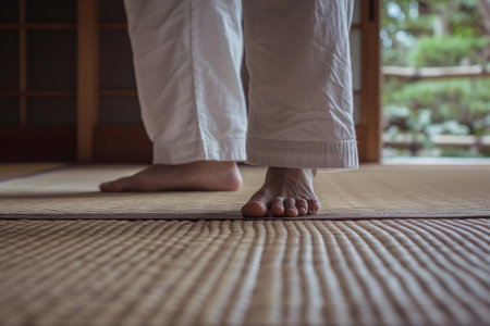 A person confidently stands on top of a sturdy wooden floor, showcasing their balance and strength, Karateka's barefoot on a tatami mat, AI Generatedの素材