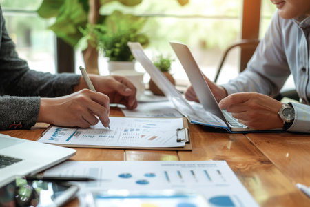 A diverse group of individuals sitting at a table, engrossed in their work as they use their laptops, Business associates negotiating business loan interest rates, AI Generatedの素材