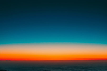 The photo captures a stunning sunset scene with vibrant colors reflecting on the oceans surface, A harmonic gradient of sunset hues from deep orange to twilight blue, AI Generatedの素材