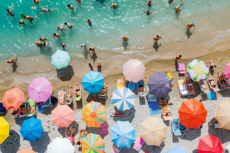 Crowd of people standing together on a sandy beach, colorful umbrellas in the background, A crowded beach dotted with colorful umbrellas and sunbathersの素材
