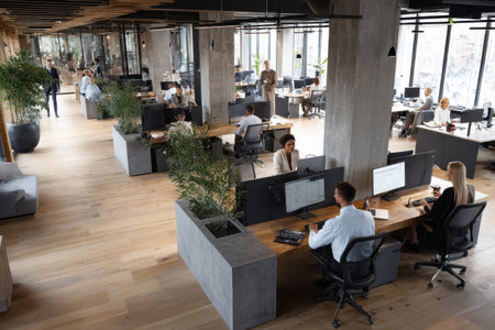 Elevated view showcasing a bustling open plan office environment during regular business hours with employees engaged in various tasksの素材