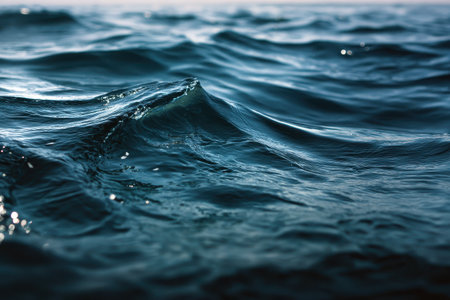 Serene closeup of calm sea water waves showcasing gentle movement and soothing reflections under daylight conditionsの素材