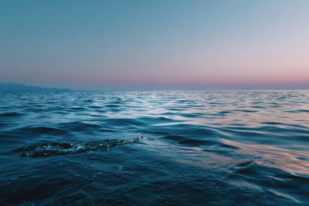 Serene ocean seascape at twilight with calm water reflecting soft pastel hues over the horizonの素材