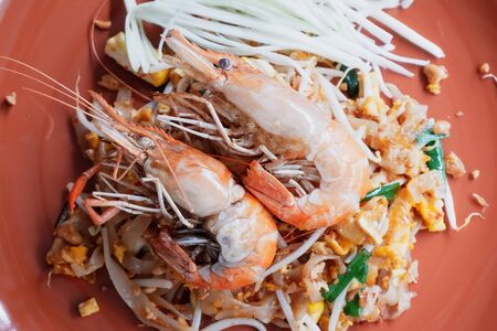 Pad Thai with fresh prawns in an orange plateの写真素材