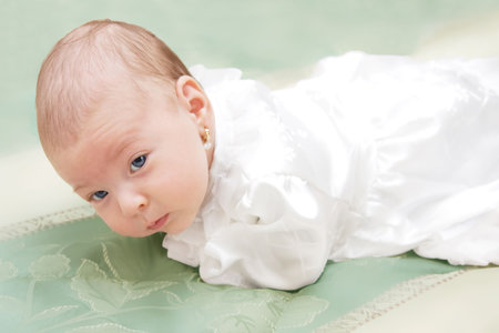 New born baby girl dressed for christening.